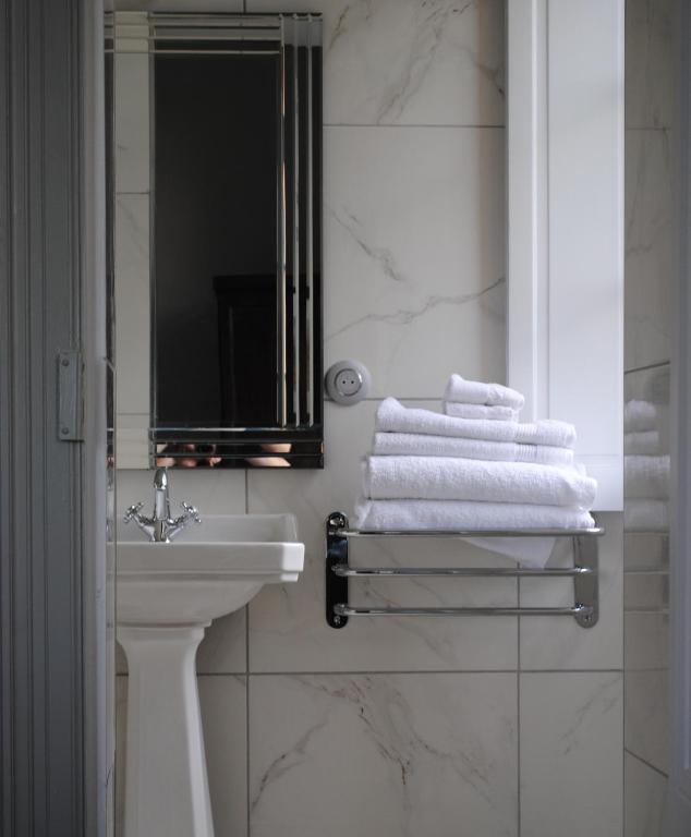 bagno con lavandino, specchio e asciugamani di Chateau Mezger ad Albefeuille-Lagarde