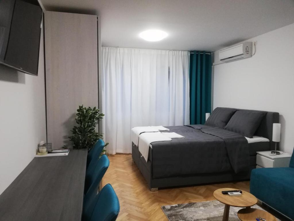 a bedroom with a bed and a tv and a couch at Apartments Ali in Zagreb