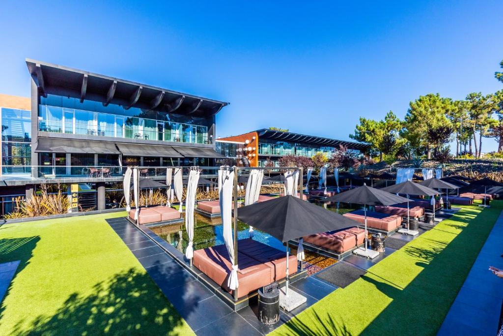 een zwembad met stoelen en parasols voor een gebouw bij Evidencia Belverde Hotel in Amora