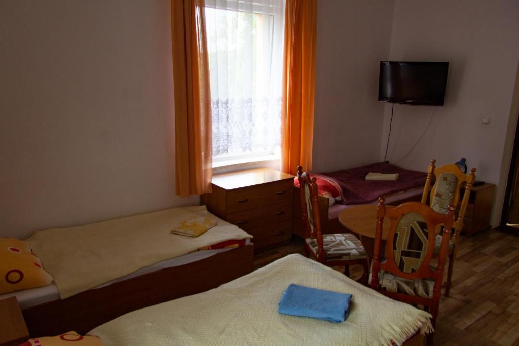 Habitación pequeña con 2 camas y ventana en Fortuna en Świeradów-Zdrój