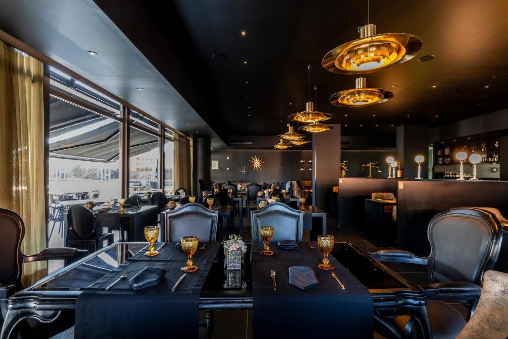 a restaurant with a long table and chairs at Evidencia Belverde Hotel in Amora