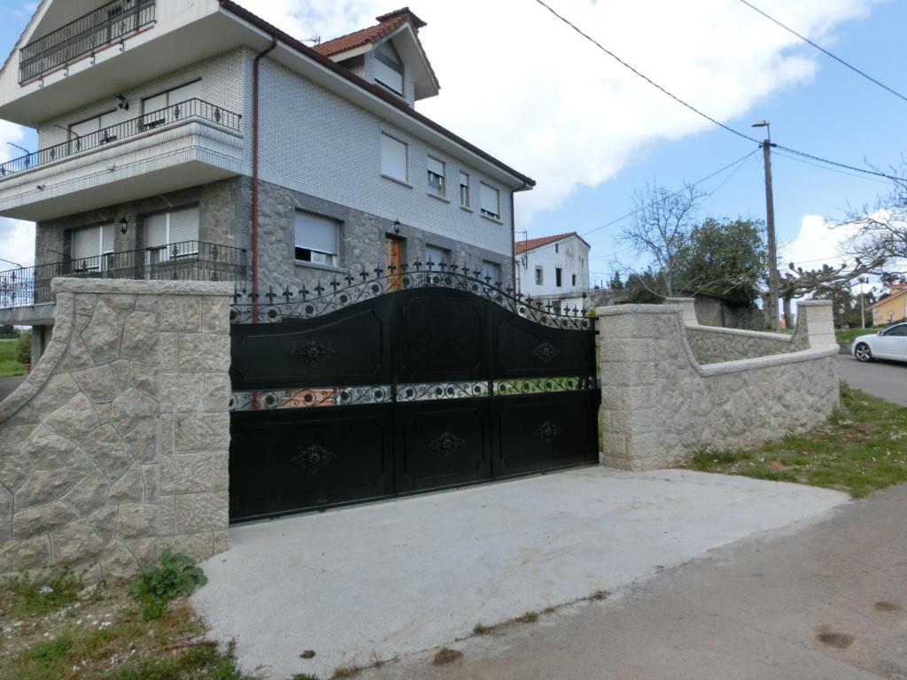 a house with a black gate in front of it at Alojamiento extrahotelero casa Ernestina in Castillo