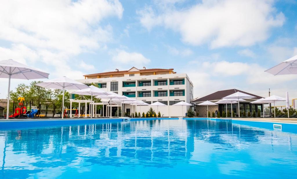 a large swimming pool with umbrellas in front of a building at WELCOME summer in Zatoka