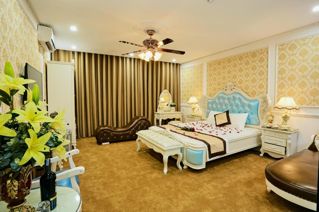 duża sypialnia z łóżkiem i wentylatorem sufitowym w obiekcie King's Hotel Mỹ Đình w mieście Hanoi
