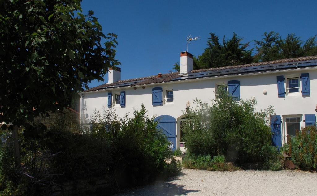 a white house with blue windows and blue shutters at La Claverie in Sainte-Radégonde-des-Noyers