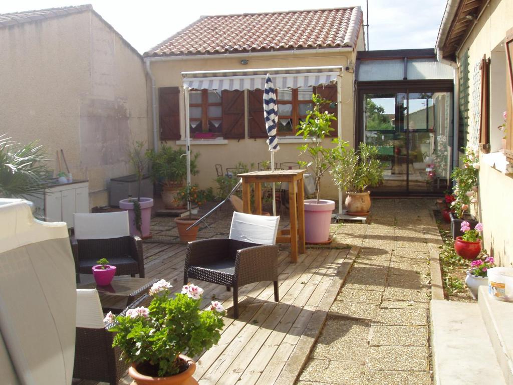 eine Terrasse mit Stühlen und Topfpflanzen in der Unterkunft maison de vacance in Pomérols