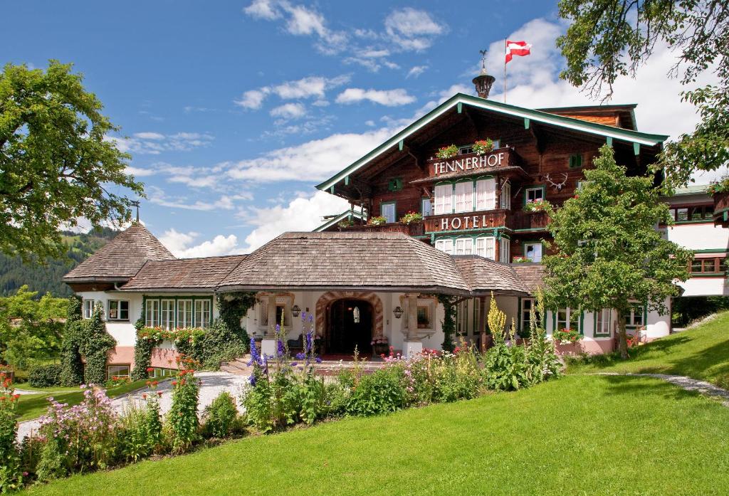 un grand bâtiment avec un drapeau en haut dans l'établissement Relais & Châteaux Hotel Tennerhof, à Kitzbühel