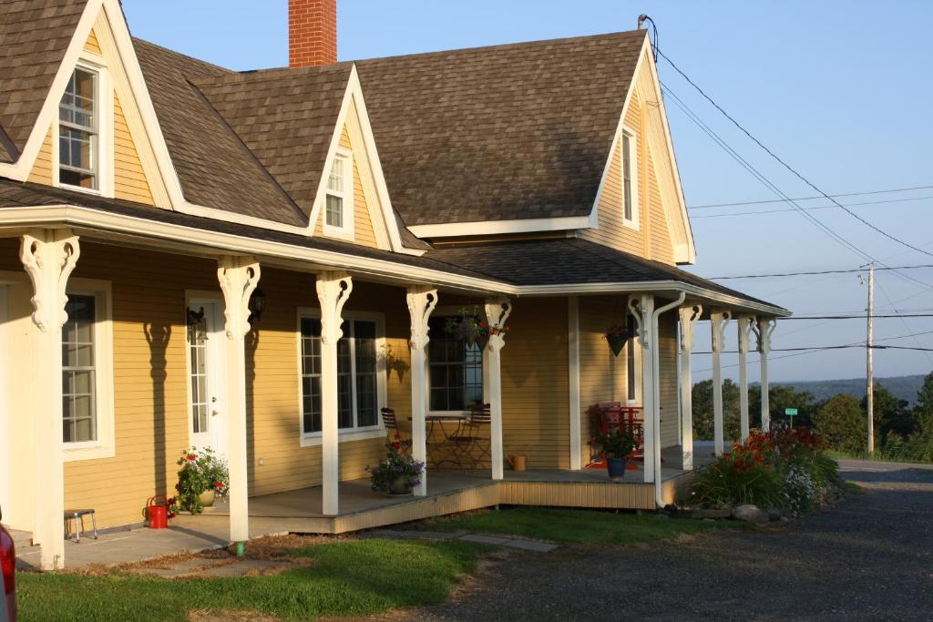 a yellow house with a brown roof at Gîte Au Blanc Marronnier in Racine