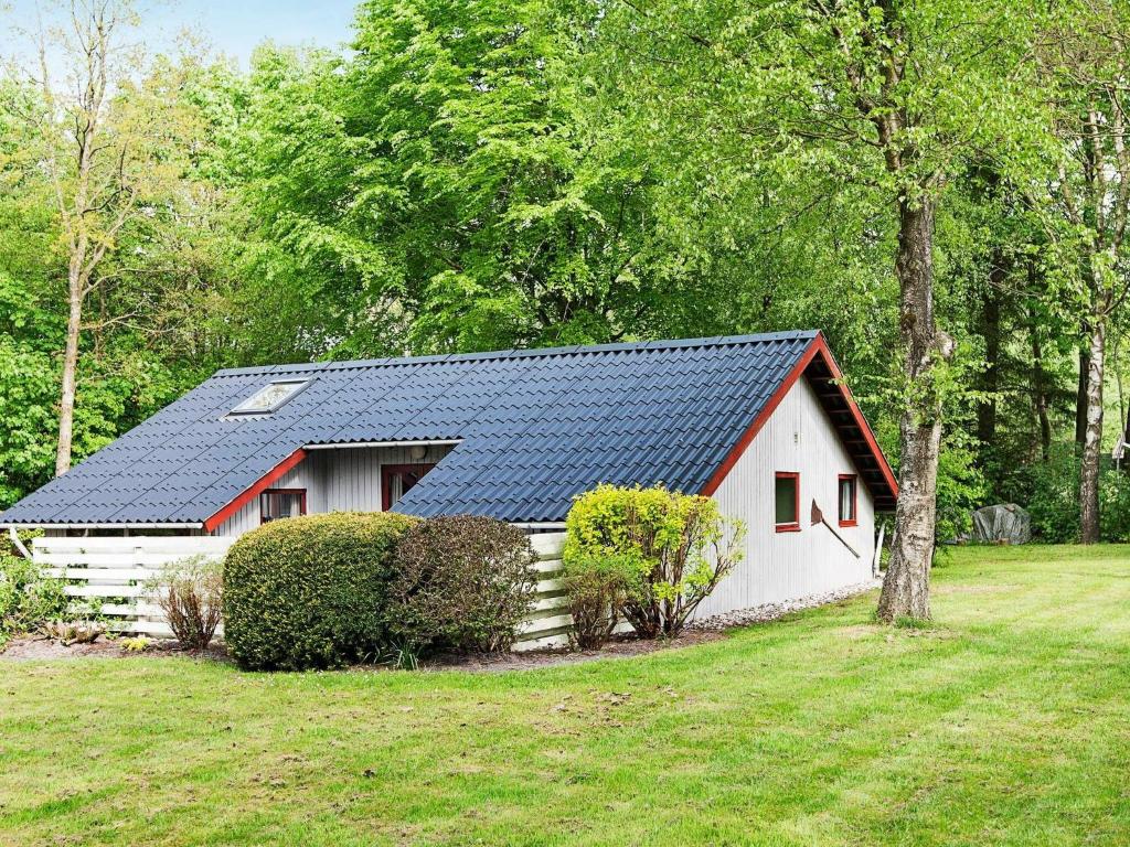 a white and red house with a solar roof at Three-Bedroom Holiday home in Toftlund 27 in Arrild
