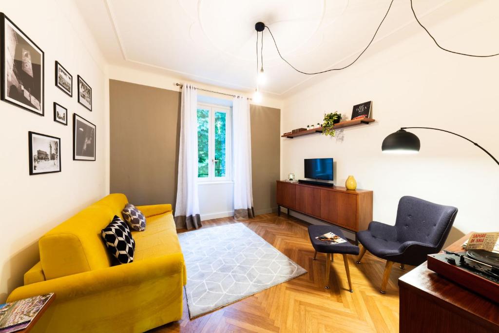a living room with a yellow couch and a chair at ReGo Holiday Apartments City Center in Bergamo