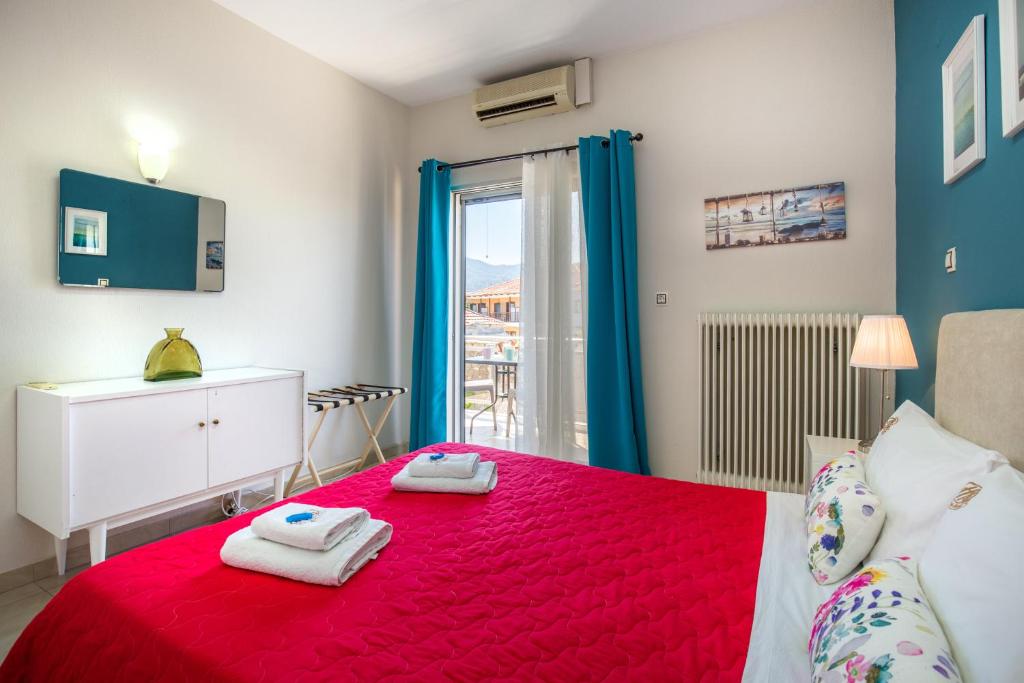 um quarto com uma cama vermelha e toalhas em Central Thassos Apartment 3 em Limenas