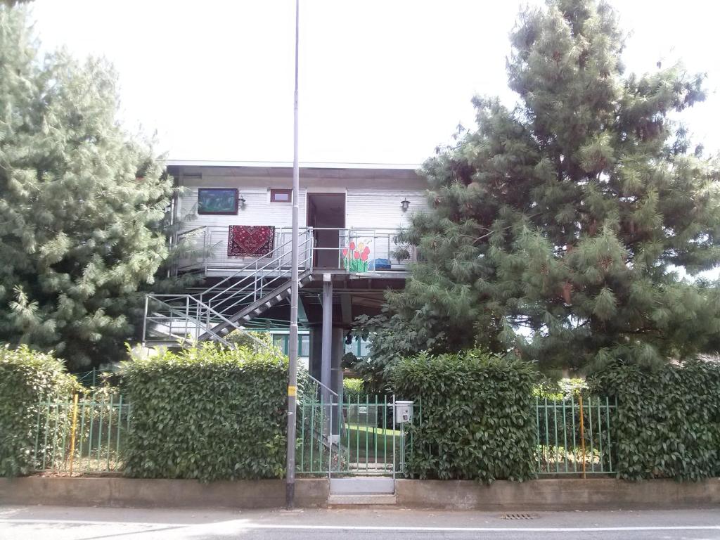 un edificio con una escalera en medio de dos árboles en BGY Airport Guesthouse, en Orio al Serio