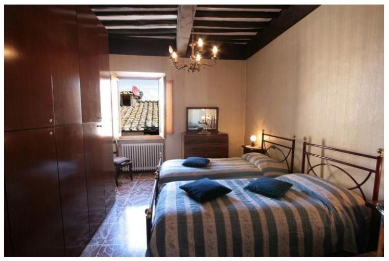 una camera con due letti con cuscini blu sopra di La Torre Useppi a San Gimignano