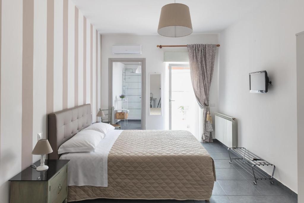 Un dormitorio con una cama grande y una ventana en B&B Vicolo Garibaldi, en Valguarnera Caropepe