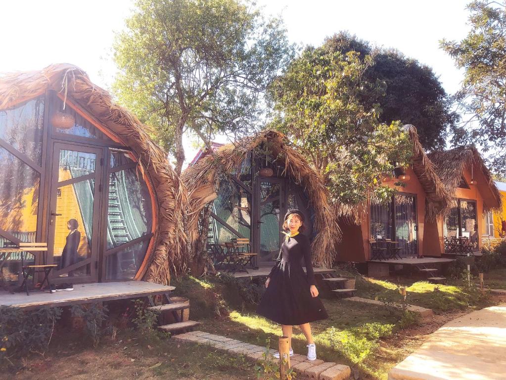 una mujer está parada frente a una casa en Fairyhouse Mộc Châu en Sơn La