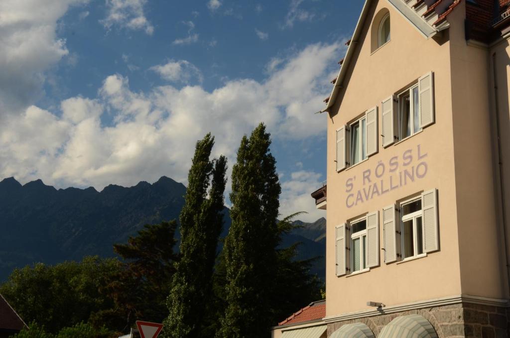 un edificio con un cartel en el costado en Albergo Cavallino s'Rössl, en Merano