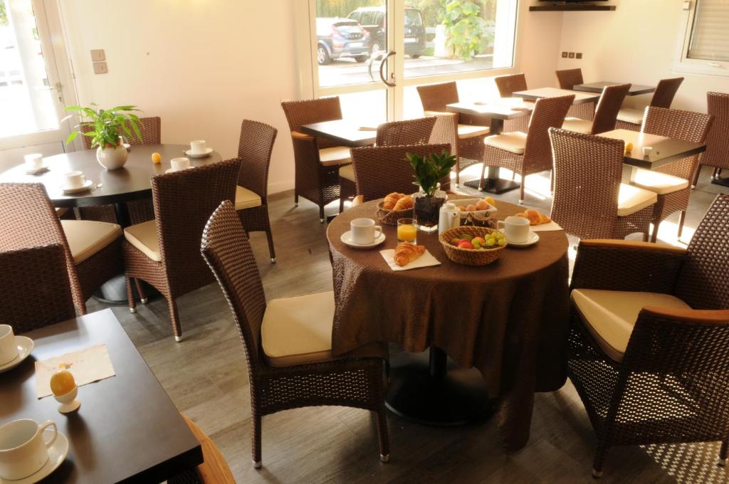 a restaurant with tables and chairs with food on them at Hôtel du Moulin in Niort