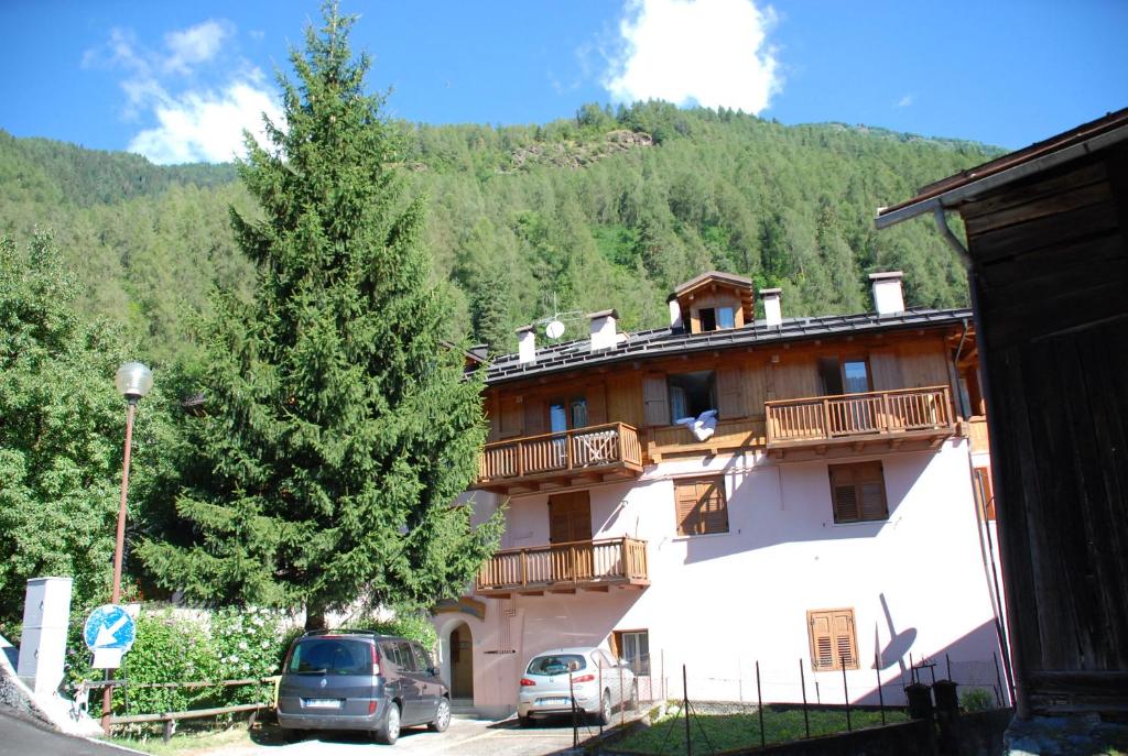 a large building with cars parked in front of it at Maso Anna in Commezzadura