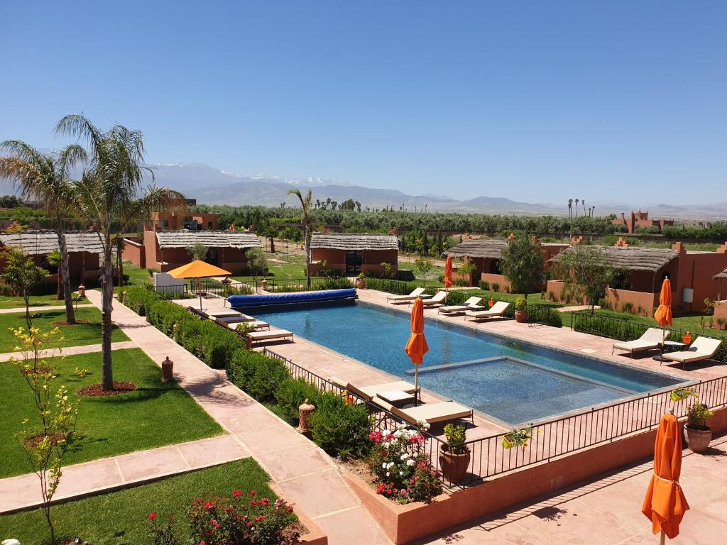 uma vista sobre uma piscina com espreguiçadeiras e um resort em Les Orangers De l'Ourika em Marrakech