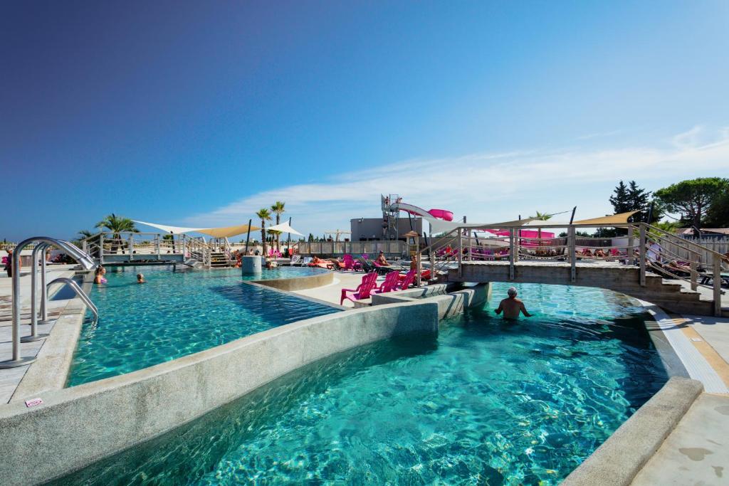 einen Pool in einem Wasserpark mit Menschen darin in der Unterkunft MAS DES LAVANDES in Sérignan