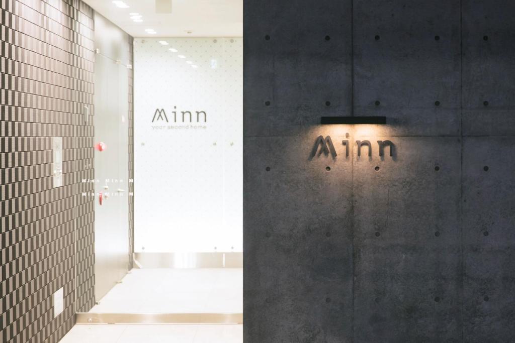 a room with a wall with an atm sign on it at Minn Umeda-North in Osaka