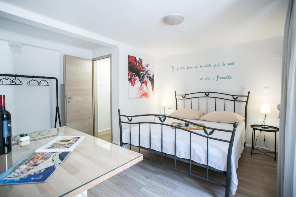 ein Schlafzimmer mit einem Bett und einem Tisch in einem Zimmer in der Unterkunft Guest house Mendi in Trogir