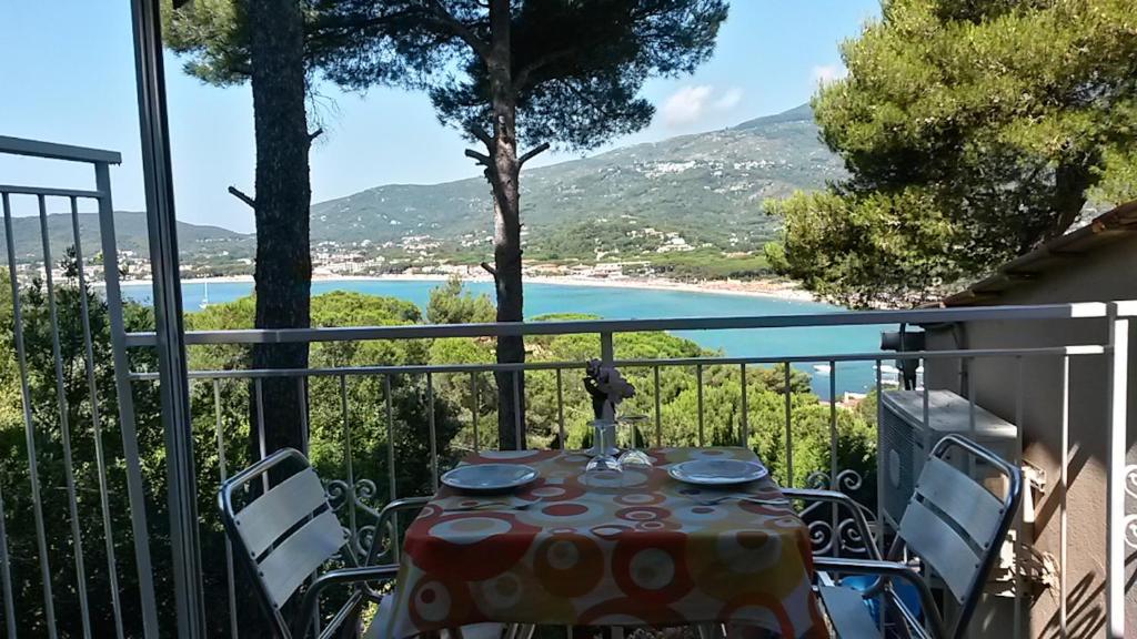 un tavolo su un balcone con vista sulla spiaggia di VacanzaMareDUE 2 Residence a Campo nell'Elba