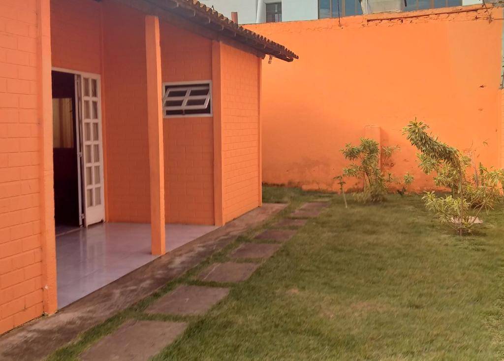 Acomodaçaoes koynonya في سيت لاغواس: منزل برتقالي مع باب مفتوح وساحة