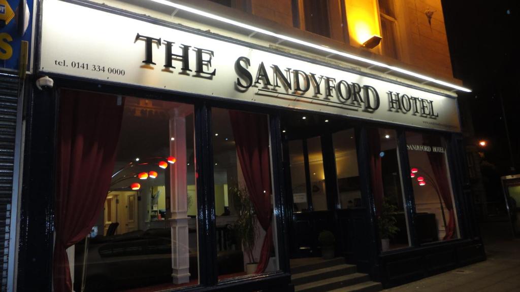 a restaurant with a neon sign on the side of the building at Sandyford Hotel in Glasgow