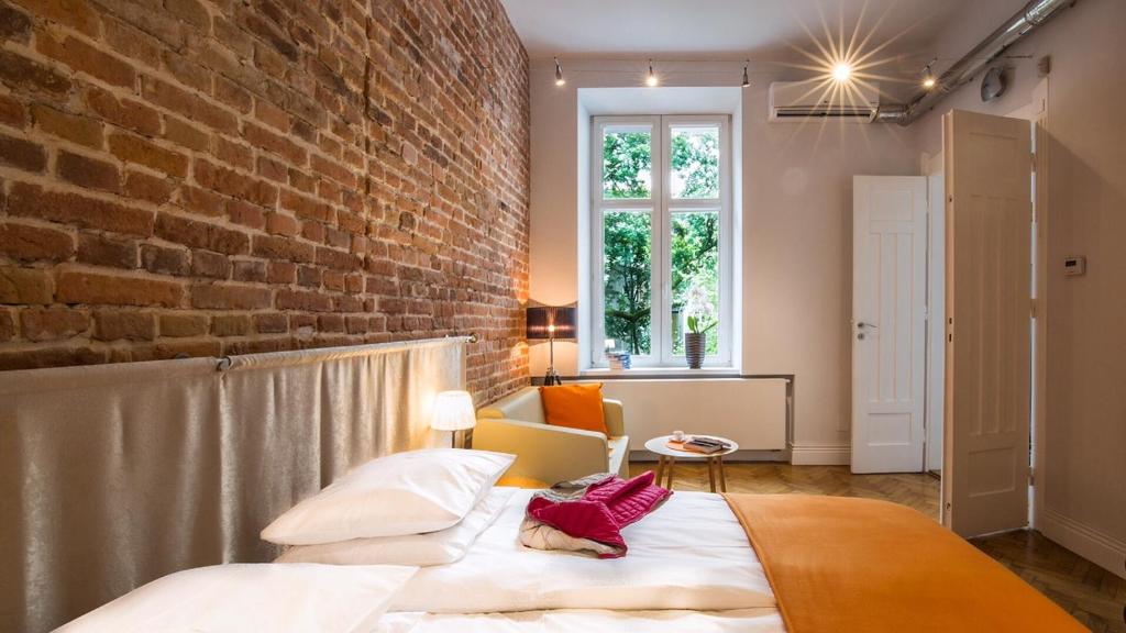 a bedroom with a brick wall and a bed at Cracowdays in Kraków