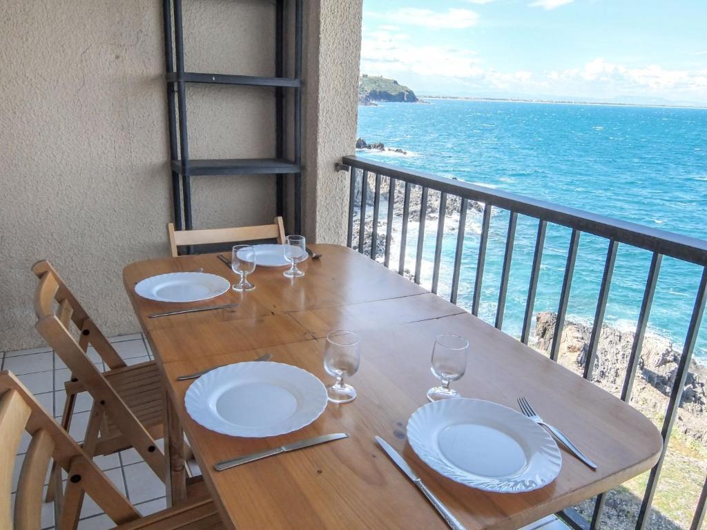 una mesa con platos y vasos en un balcón con vistas al océano en Apartment Les Roches Bleues-2 by Interhome en Collioure