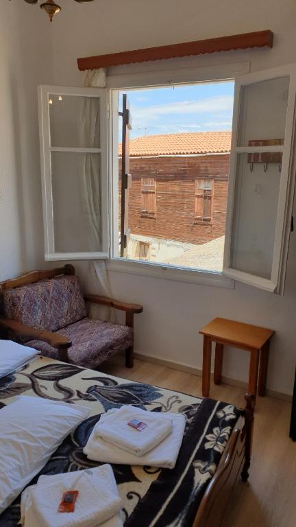 a bedroom with two beds and a large window at Maro Rooms in Chania