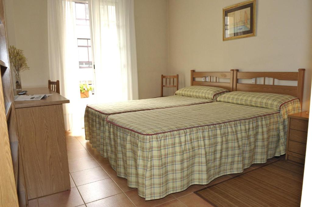 サンティアゴ・デ・コンポステーラにあるPR Nimoのベッドルーム1室(ベッド2台、窓付)