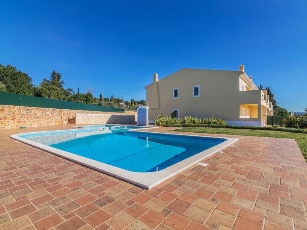 a swimming pool in front of a house at Holiday Home Vila Caravela by Interhome in Estevais