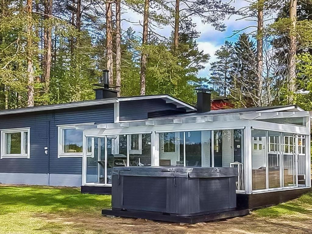 una casa con un porche cubierto con árboles en Holiday Home Einola by Interhome en Laiska