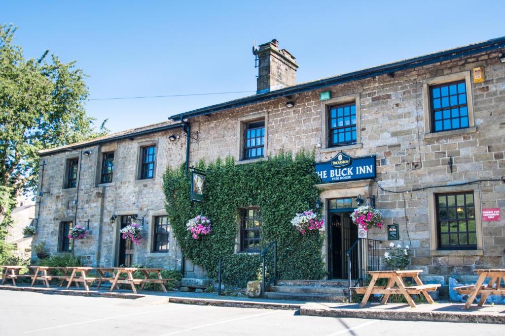 un viejo edificio de ladrillo con flores. en The Buck Inn en Buckden