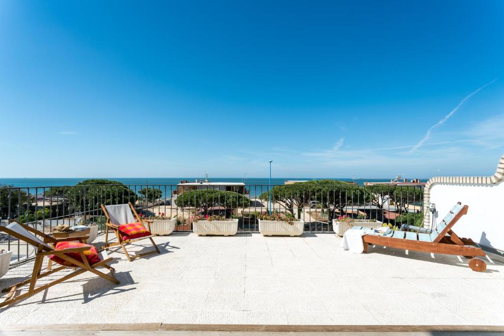 d'une terrasse avec des chaises et l'océan en arrière-plan. dans l'établissement Apartamento Conquistadores Mazagon, à Mazagón