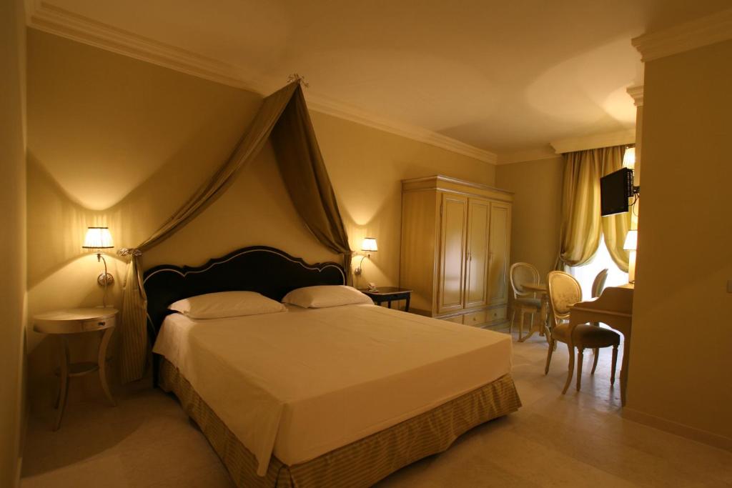 ヴィエステにあるPalace Hotel Viesteのベッドルーム1室(ベッド1台、テーブル、椅子付)