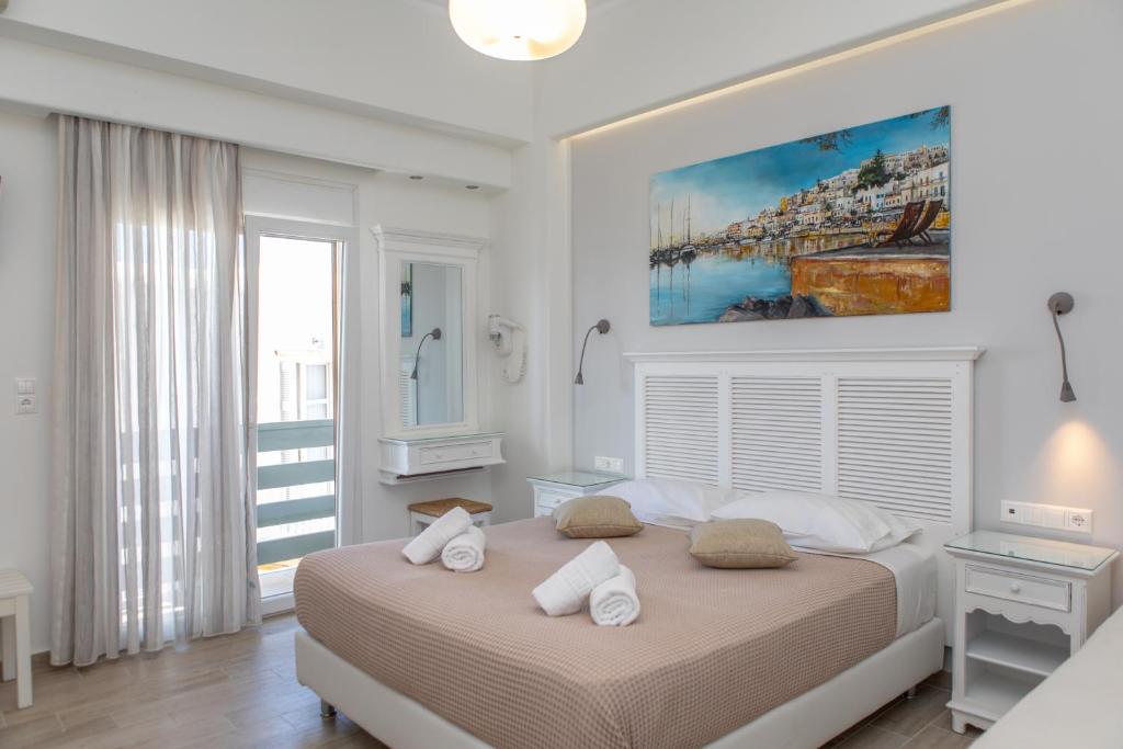 una camera bianca con un grande letto con due cuscini di Naxos Illusion Nikos Verikokos a Naxos Chora