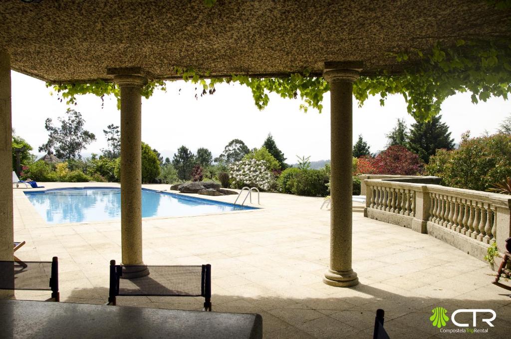 a pergola with a swimming pool in a yard at AMAZING VILLA CTR in Brion