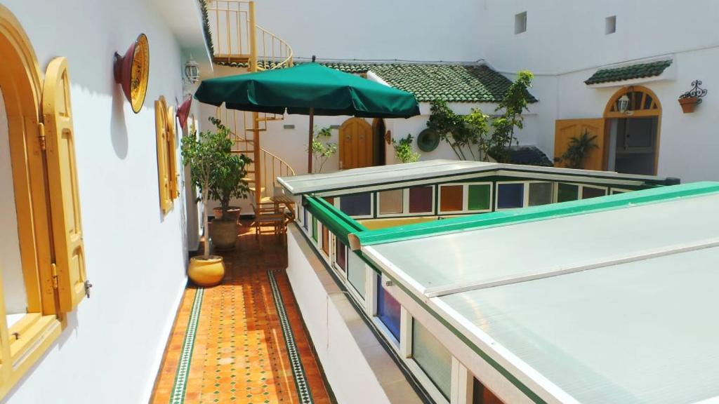 a building with a green umbrella and a hallway at Riad Dar Zouhour in Rabat