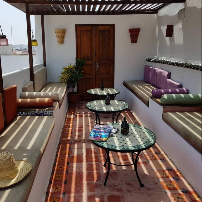 a room with two tables and couches on a balcony at Riad Dar Zouhour in Rabat