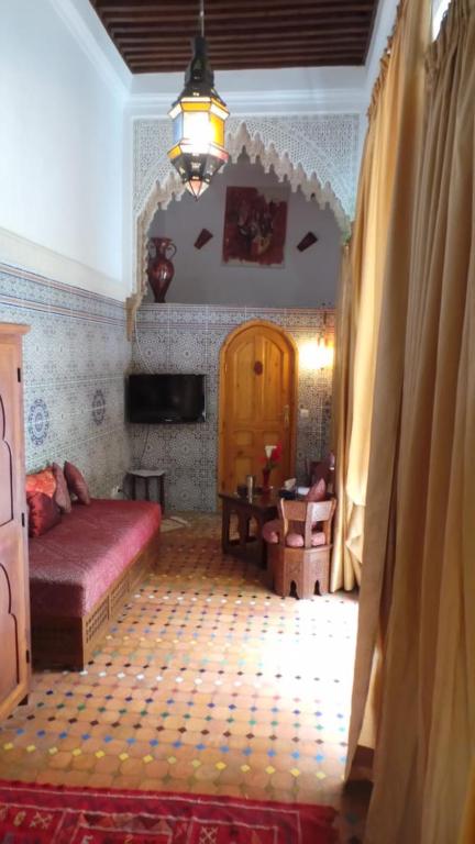 a bedroom with a bed and a tv in a room at Riad Dar Zouhour in Rabat