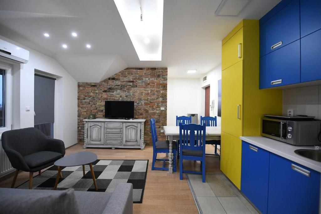 une cuisine avec des armoires bleues, une table et des chaises dans l'établissement Cozy and Lovely Appartment, à Jagodina