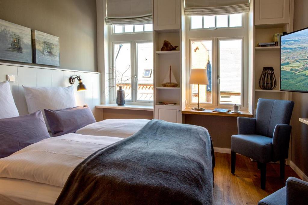 1 dormitorio con 1 cama, 1 silla y ventanas en Logierhaus K15 Appartement 6 en Borkum