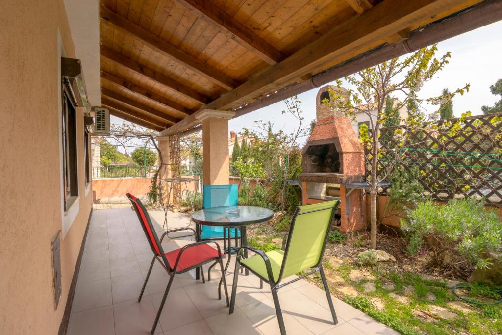 a patio with a table and chairs and an outdoor oven at One bedroom apartment near the Kamenjak park in Prematura in Premantura