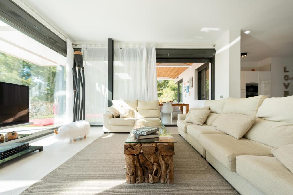 a living room with a white couch and a coffee table at Nyumba ya Sun in Cala Tarida