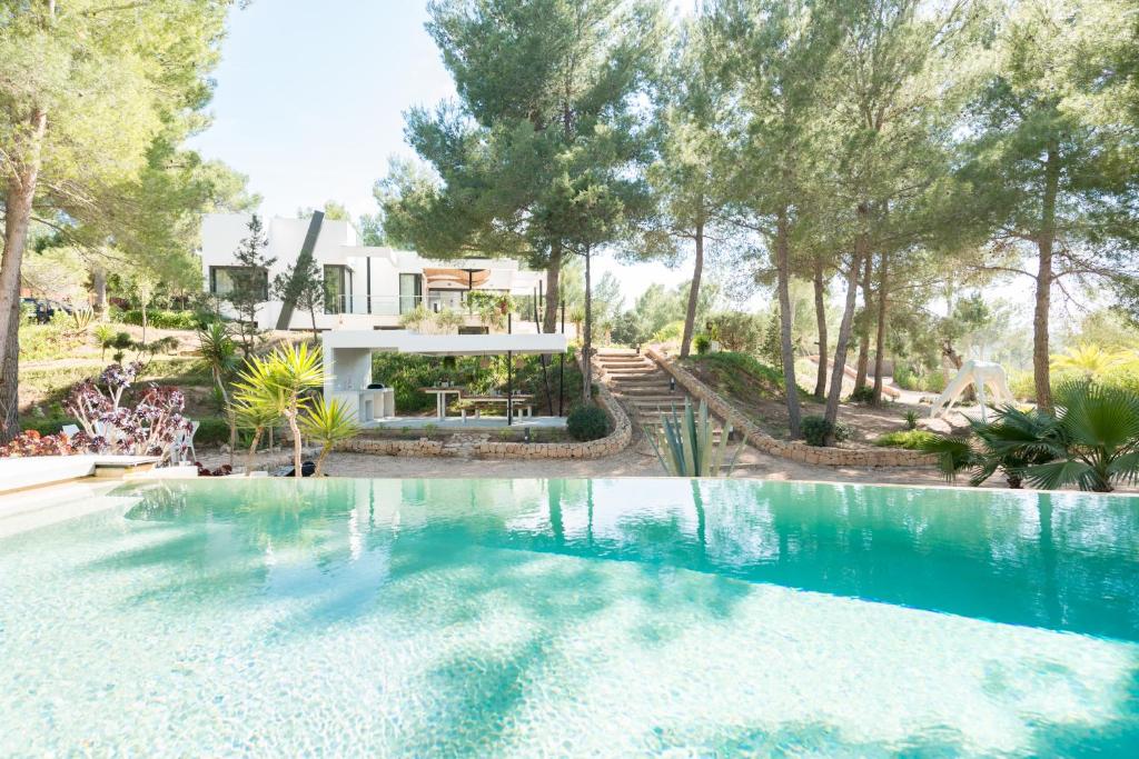 a swimming pool in front of a house at Nyumba ya Sun in Cala Tarida