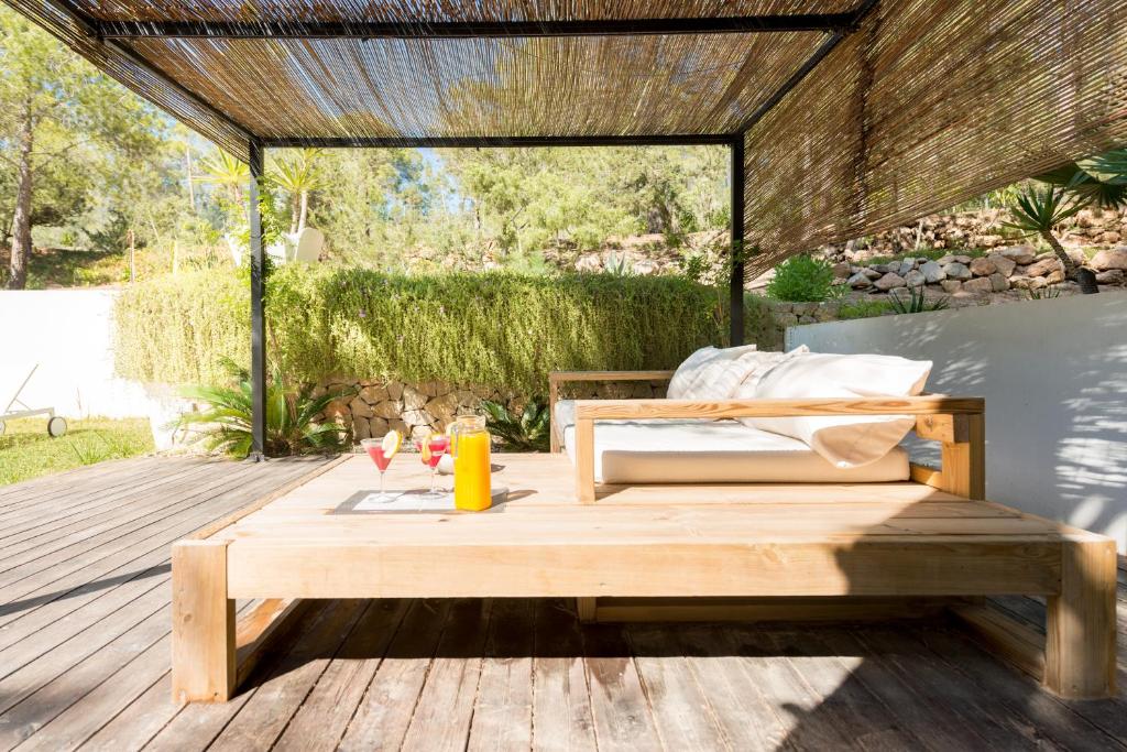 a wooden bed and a table on a deck at Nyumba ya Sun in Cala Tarida