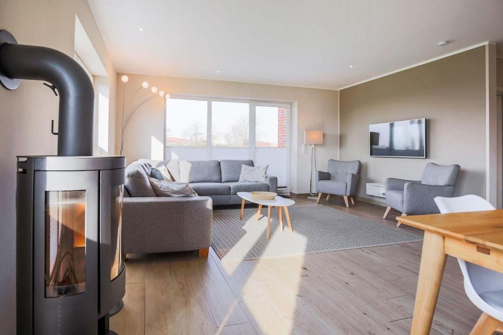 a living room with a fireplace and a couch at Buedlfarm-Wohlfuehlhuette in Fehmarn